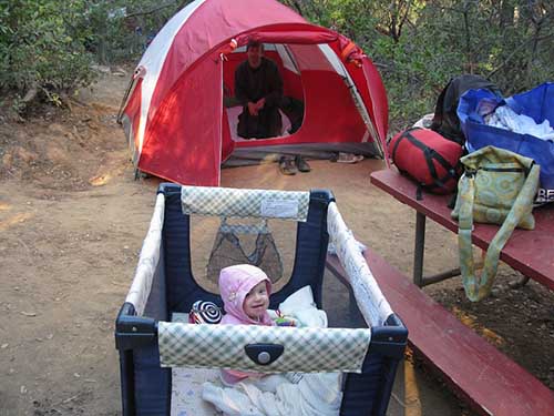 baby in a portable play pen while camping