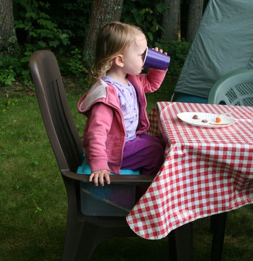 baby sitting on a box while camping