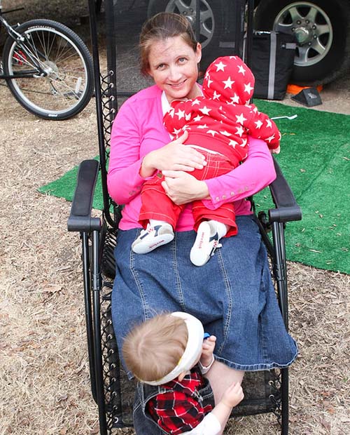 mom with babies in comfortable chair while camping