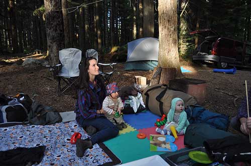 sitting on a picnic blanket while camping with babies