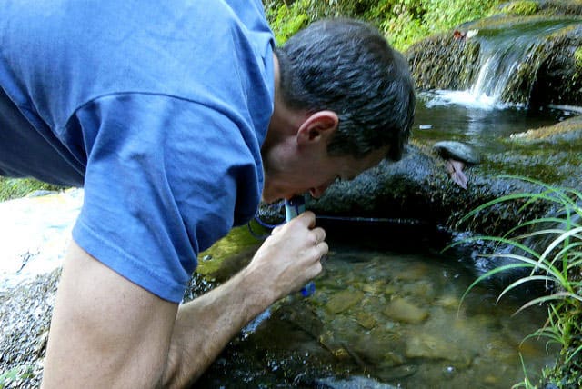 using the LifeStraw to drink from puddle