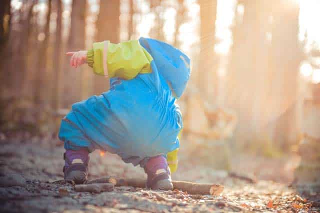 toddler playing in rain suit