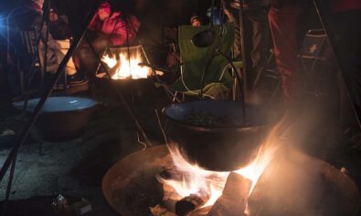 cooking over a campfire with a tripod